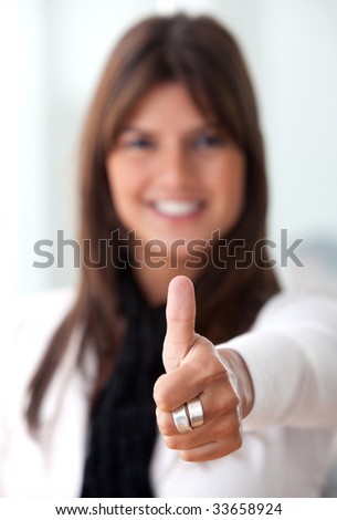 stock photo : Thumbs up business woman smiling in an office