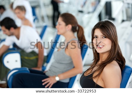 Beautiful girl at the gym with people behind