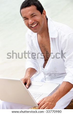 Man at the beach with a laptop computer