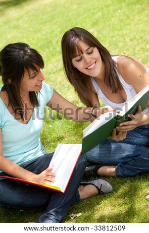 Beautiful casual girls studying with notebooks outdoors