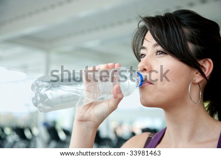 Portrait of a beautiful woman drinking water at the gym