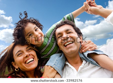 happy family portrait outdoors smiling with a blue sky