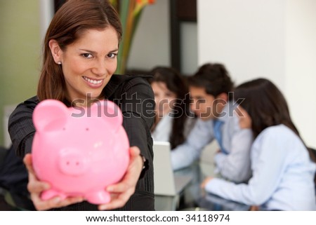 Business woman at an office holding a piggy bank