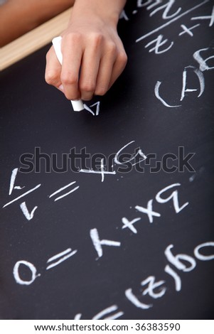 Someone writing maths equations on a chalkboard