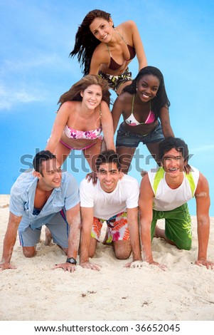 Group of people making a human pyramid at the beach