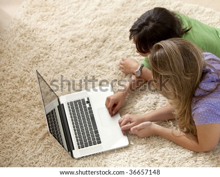 women lying on the floor with a laptop computer