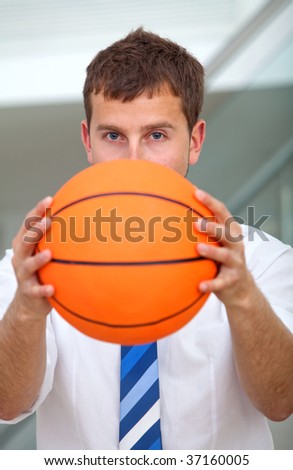 Business man covering his face with a basketball