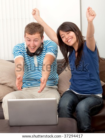 Happy couple at home watching something on the computer