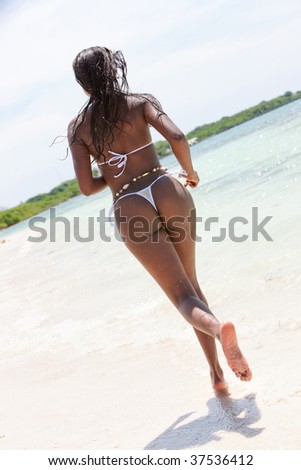 stock photo : Beautiful black woman running on the beach in bikini
