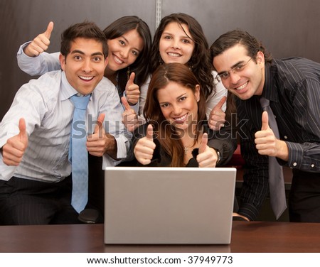 Business group with thumbs up in an office