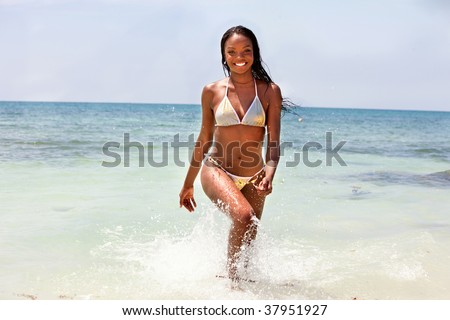 Beautiful black woman walking in the ocean