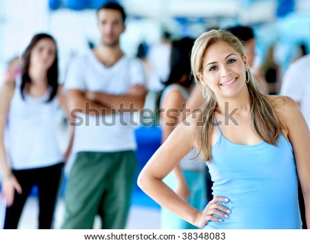 Woman portrait at the gym with people behind her