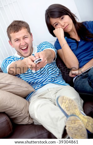 Beautiful young couple watching tv at home