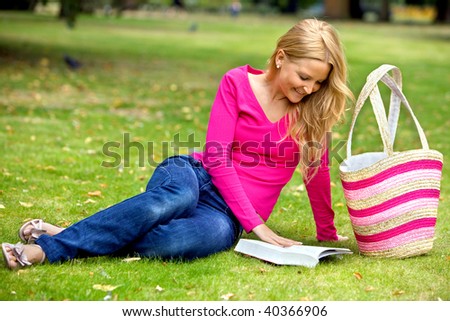 Beautiful woman reading a book at the park
