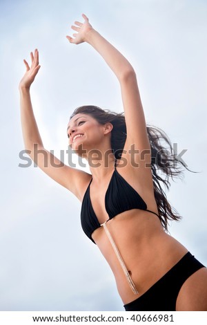 freedom woman with arms up having fun at the beach