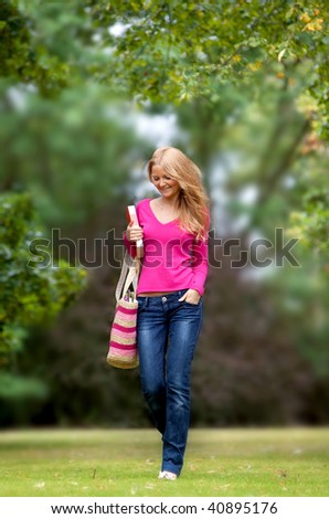 Female student walking through the campus smiling