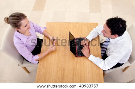 business couple smiling and having an interview in an office