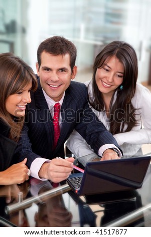 Teamwork smiling with a laptop at the office