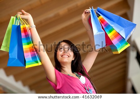 Happy shopping woman with bags and arms opened