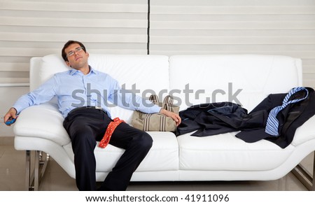 Exhausted business man lying on the sofa with a mess