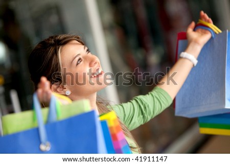 Happy woman with her arms opened holding shopping bags