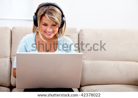 Casual student listening to music while studying on a laptop computer