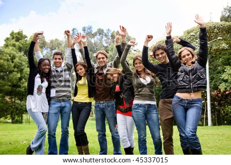 Excited group of people smiling with their arms up