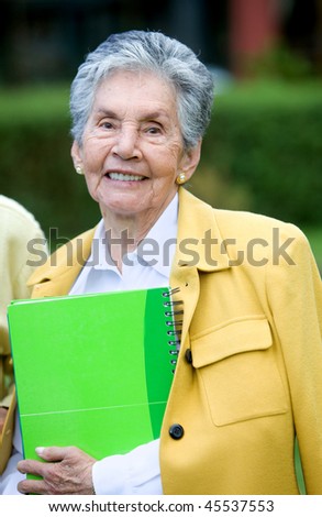 Beautiful elder woman with a notebook outdoors