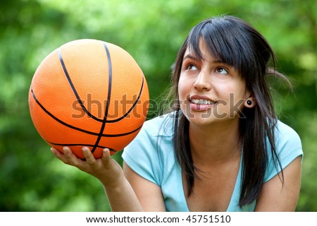 Girl holding a basketball at the park