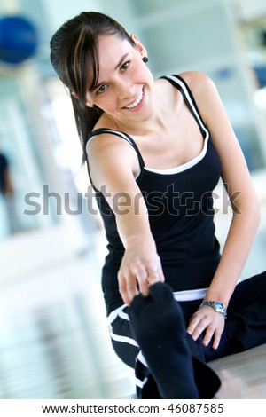 Woman doing stretching exercises on the floor at the gym