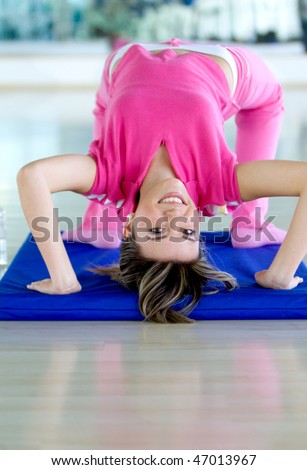 girl at the gym bending backwards over a mat