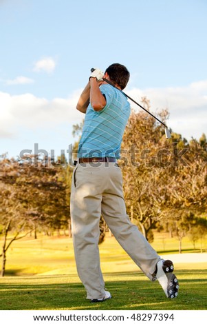 Full body young man outdoors playing golf hitting the bal