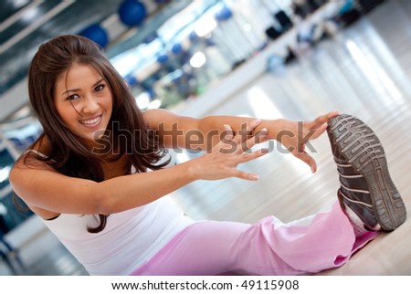 woman doing stretching exercises on the floor at the gym