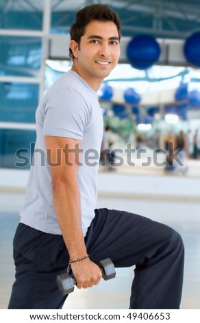 Handsome man exercising with weights at the gym