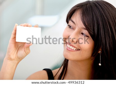 Woman displaying a business card and smiling