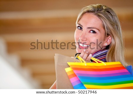 Beautiful shopping woman carrying bags and smiling