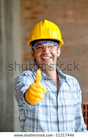 Worker at a construction site with thumbs up and smiling
