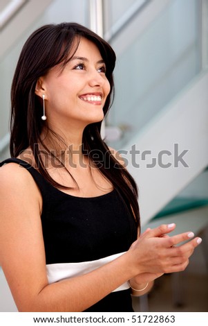 Business woman clapping and smiling at the office