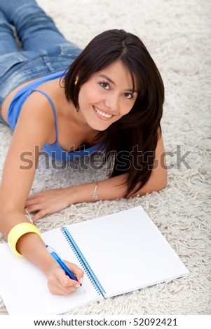Beautiful woman lying on the floor and studying at home