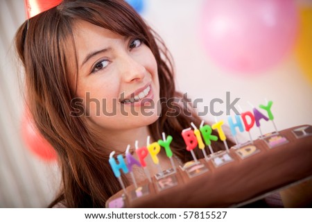 Happy girl smiling with a birthday cake in front of her face