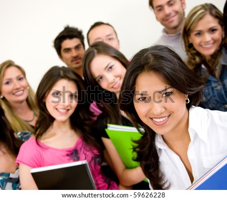 Group of university students smiling and holding notebooks