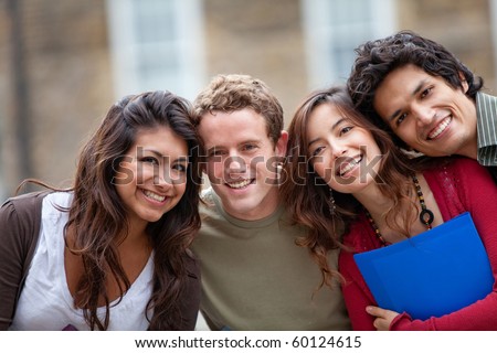 Happy group of students outdoors holding notebooks