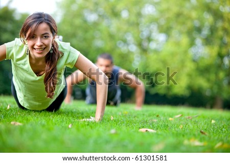 Fit people doing push-ups at the park