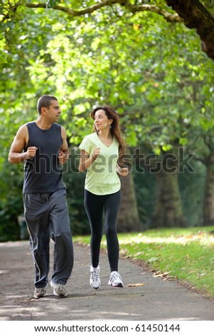 Happy couple jogging at the park - fitness concepts