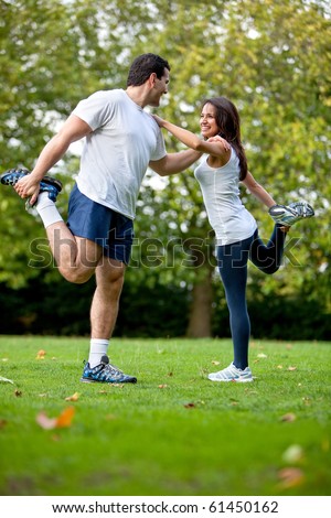 Fit woman and her sports trainer stretching outdoors