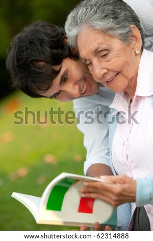 Portrait of a grandma and grandson reading a book outdoors