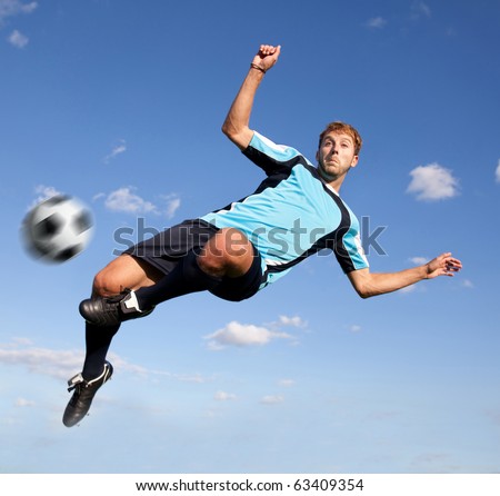 Male football player kicking the ball in the air
