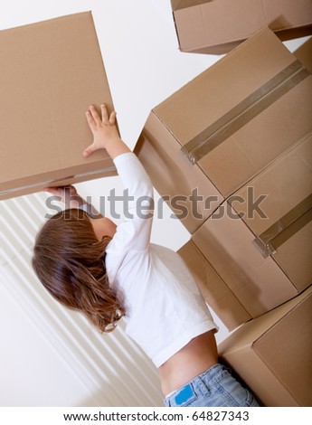 Boy playing with cardboard boxes trying to lift them up