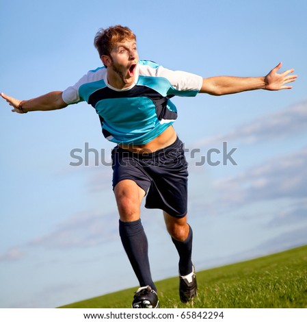 Footballer running on the field celebrating a goal