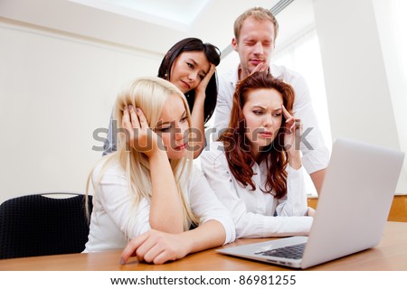Worried business group going online on a laptop at the office